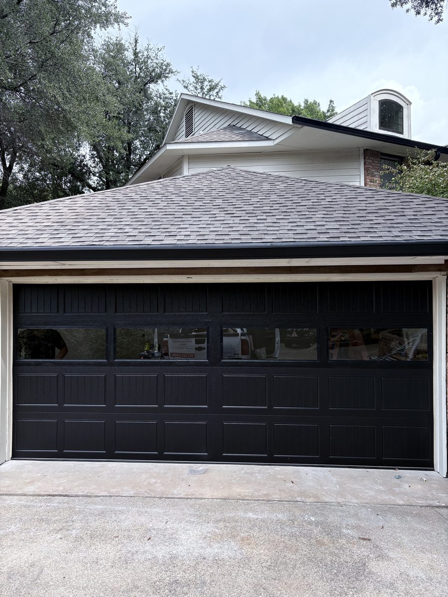 Black carriage-house garage door with windows on a McKinney home