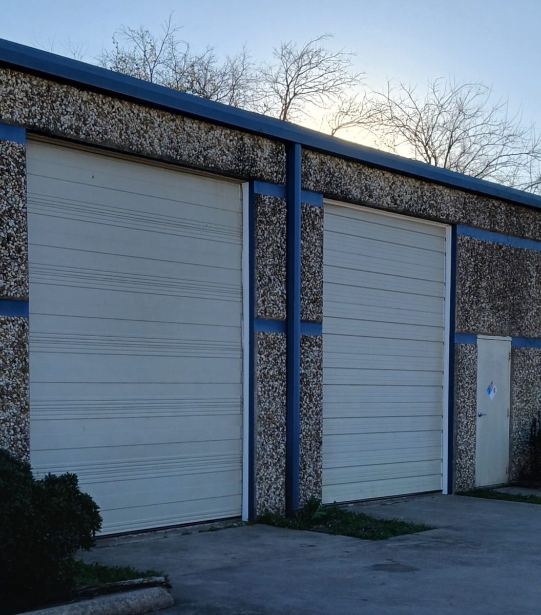 Two commercial roll-up doors on a steel-framed building in Lewisville, Texas