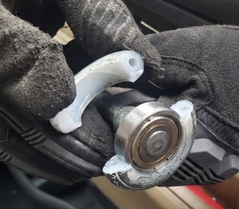 A shattered nylon garage door roller with the bearing exposed
